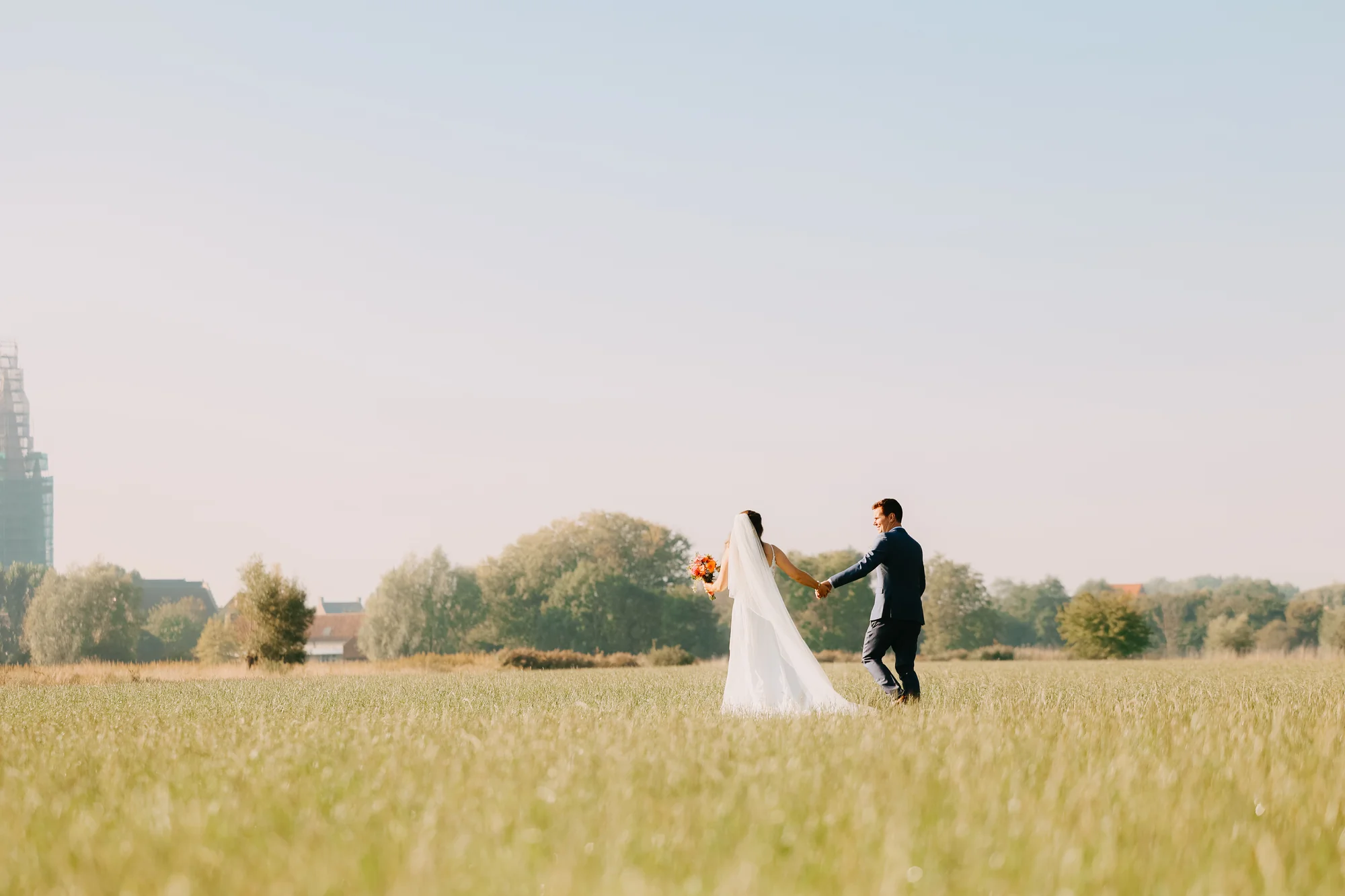 Een foto van een kussend bruid en bruidegom voor een kerk